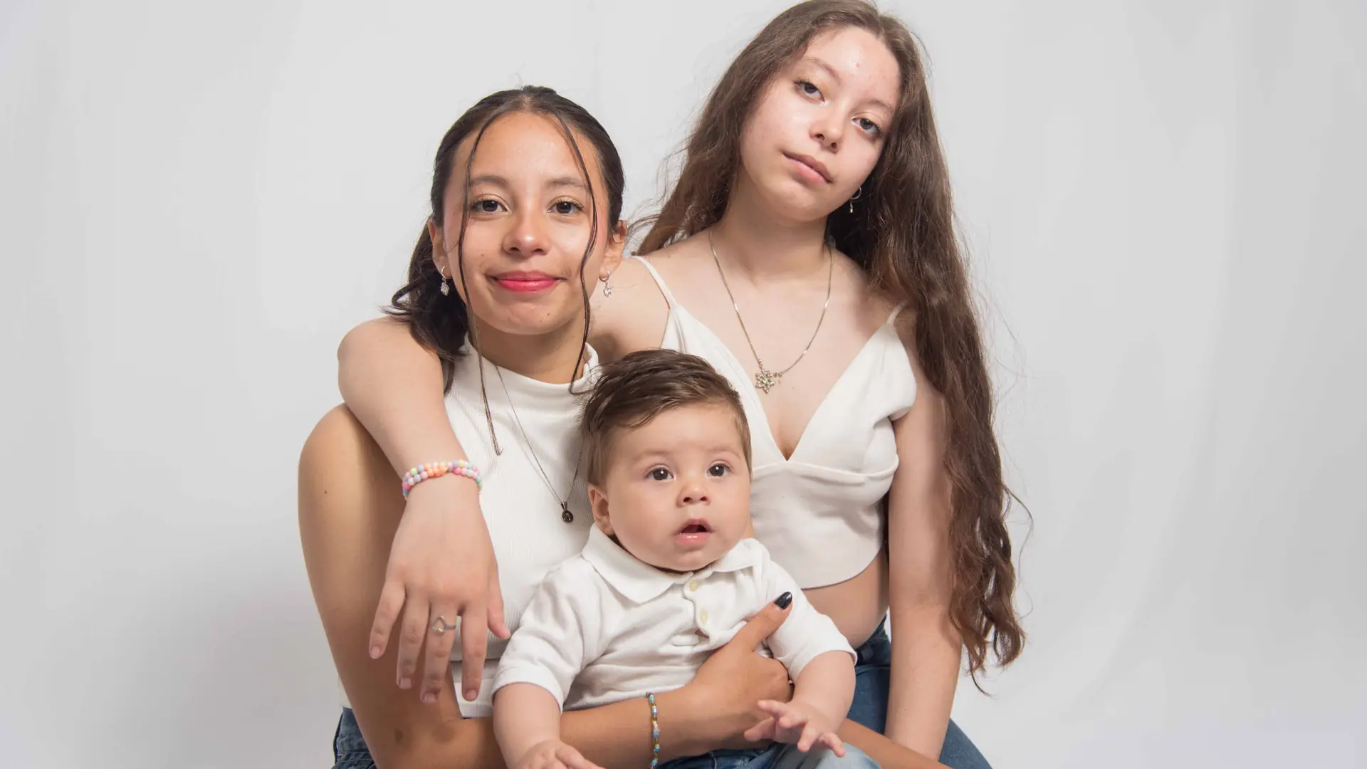 Dos hermanas con su hermanito en una sesión de familia en estudio
