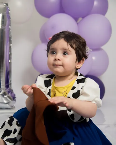 Primer año en estudio, miradas curiosas entre globos lila: foto 1 de 5